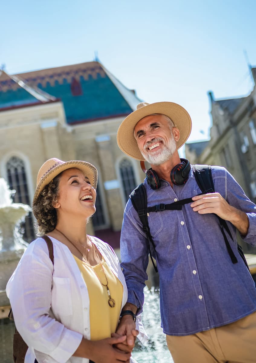 An older couple sightseeing in a sunlit town square