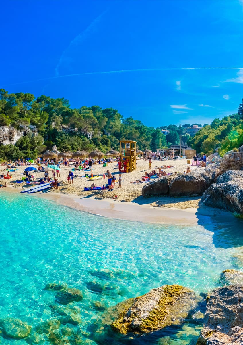 A sunlit beach cove with clear turquoise water